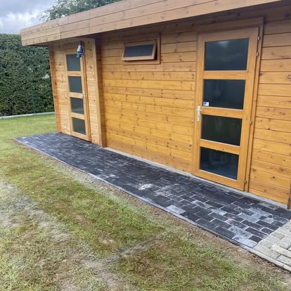 Houten tuinhuis met kasseipad ervoor